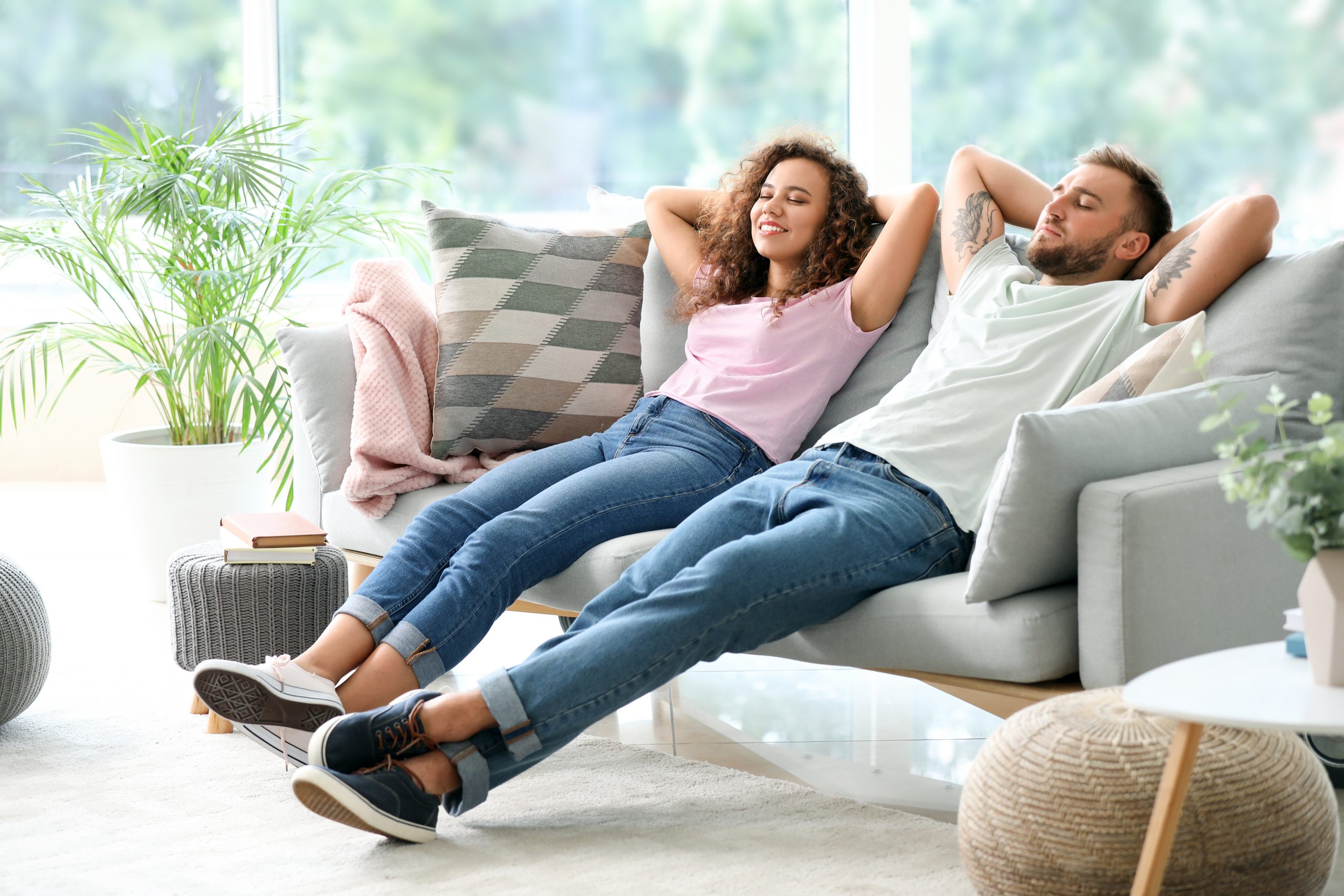 Greeley Happy young couple relaxing on sofa at home